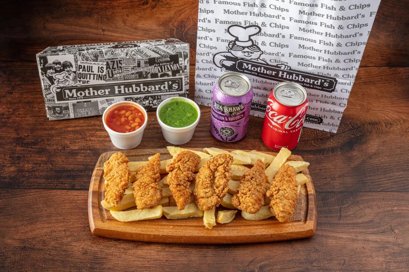 Crispy chicken strips on chips on a wooden board, with beans, mushy peas and two cans