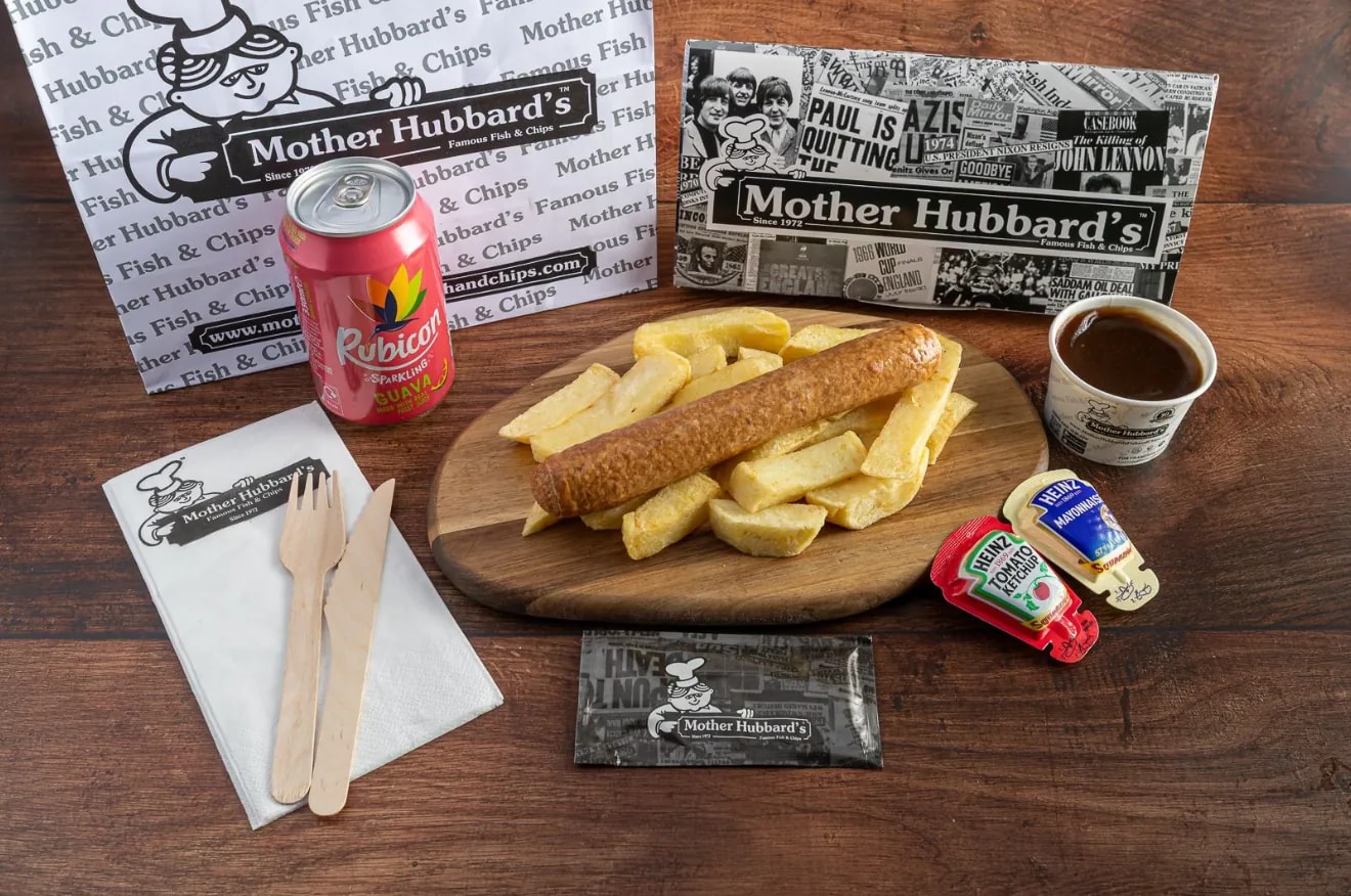 A sausage on chips with gravy, a can of Rubicon and wooden cutlery