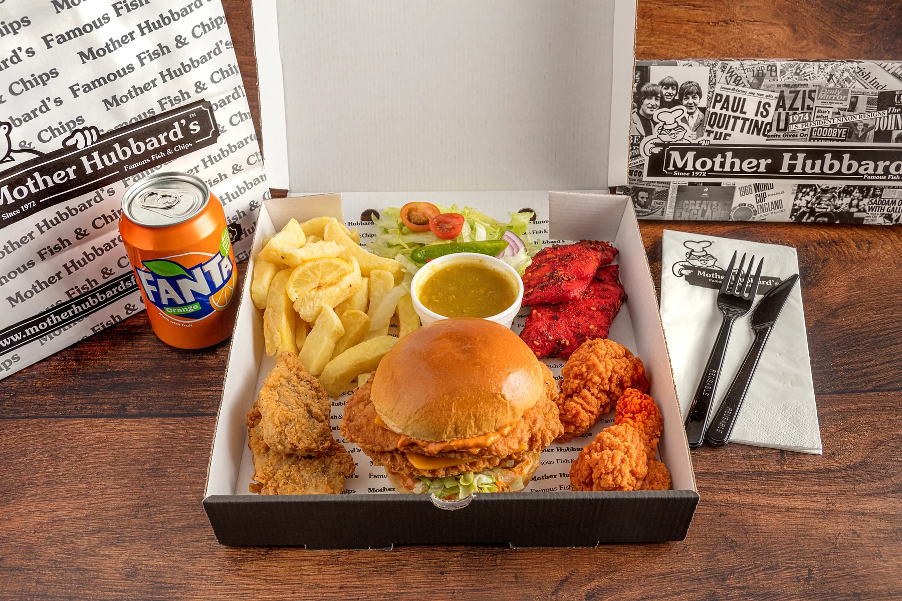 A munch box with a burger, fried chicken, chips and a drink